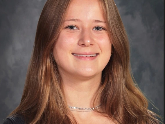 Headshot of long blonde hair person with silver necklace and black shirt. 