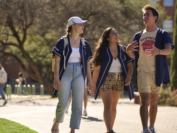 Group of three students walking around campus. 