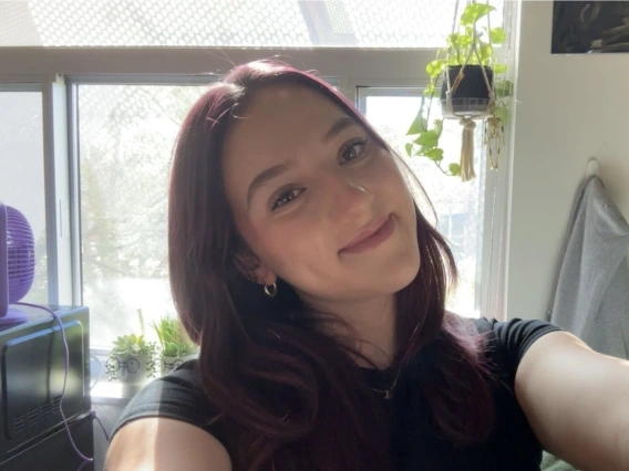 Person with long dark red hair taking a selfie.