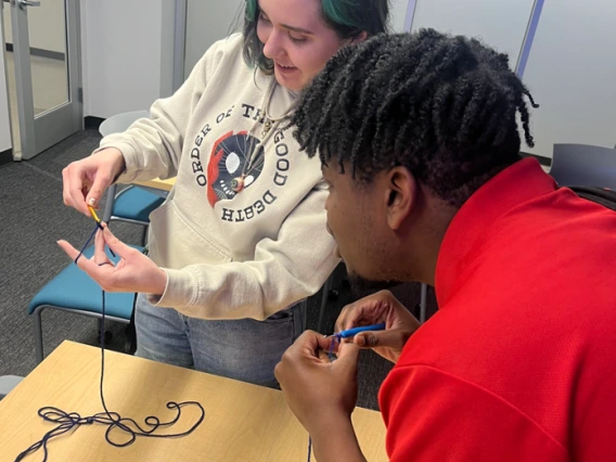 Person teaching other person how to crochet