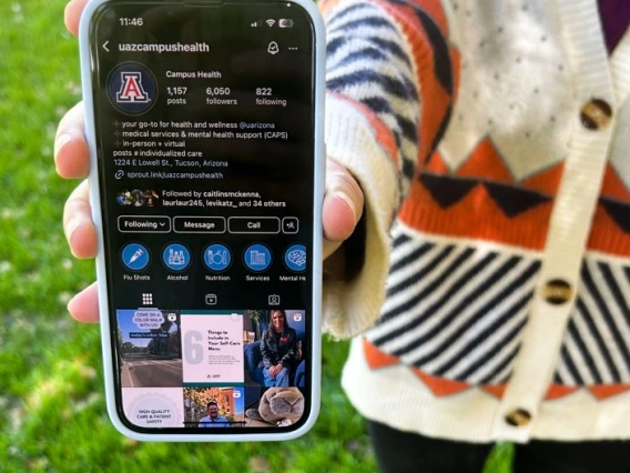 Person holding phone with @UAZCampusHealth instagram profile