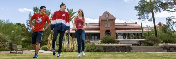3 Students walking in front of old main