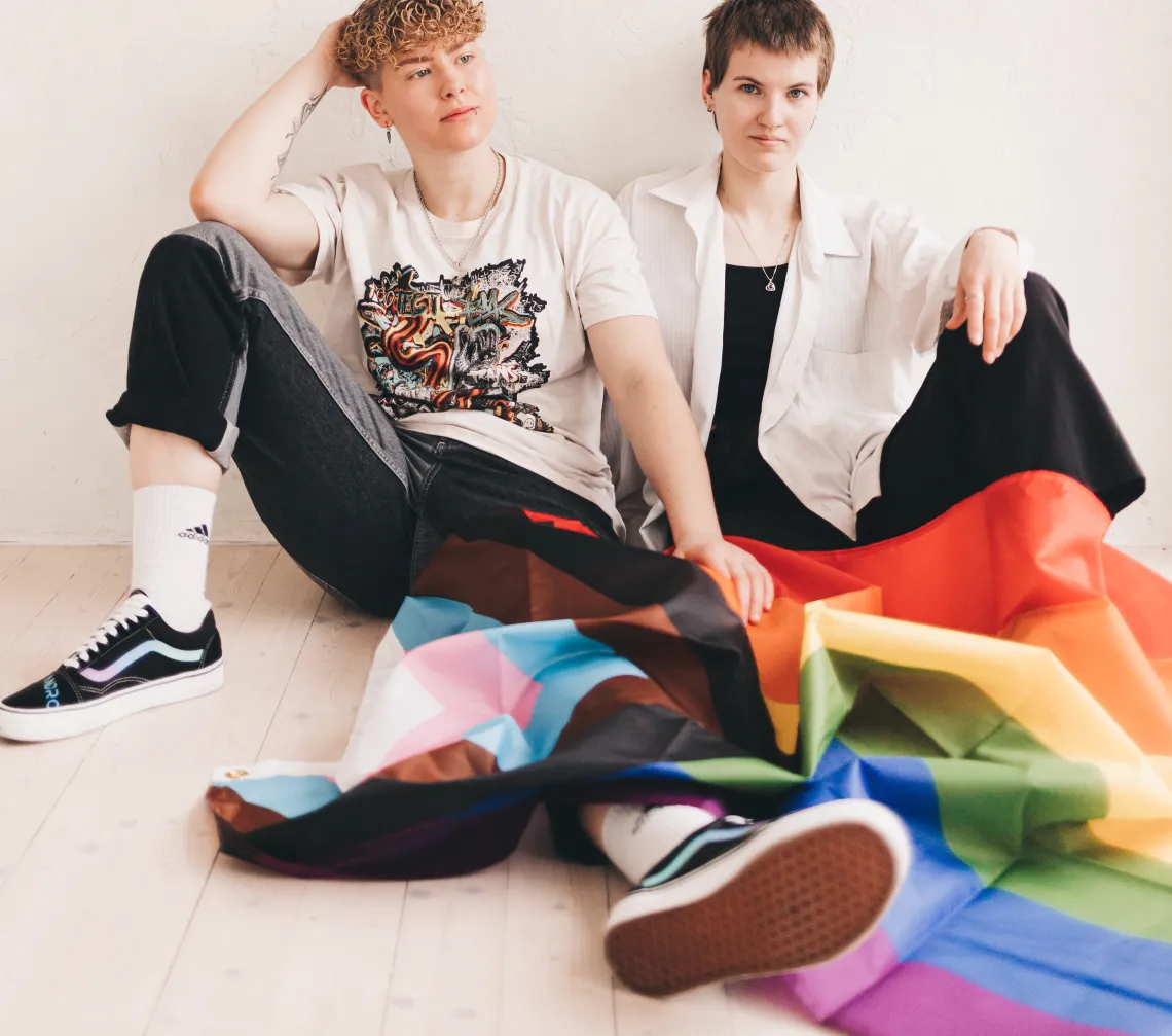 People Sitting with Progress Pride Flag