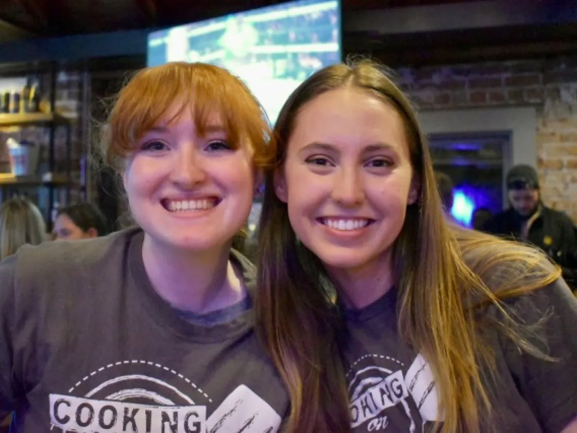 2 girls smiling at camera. 