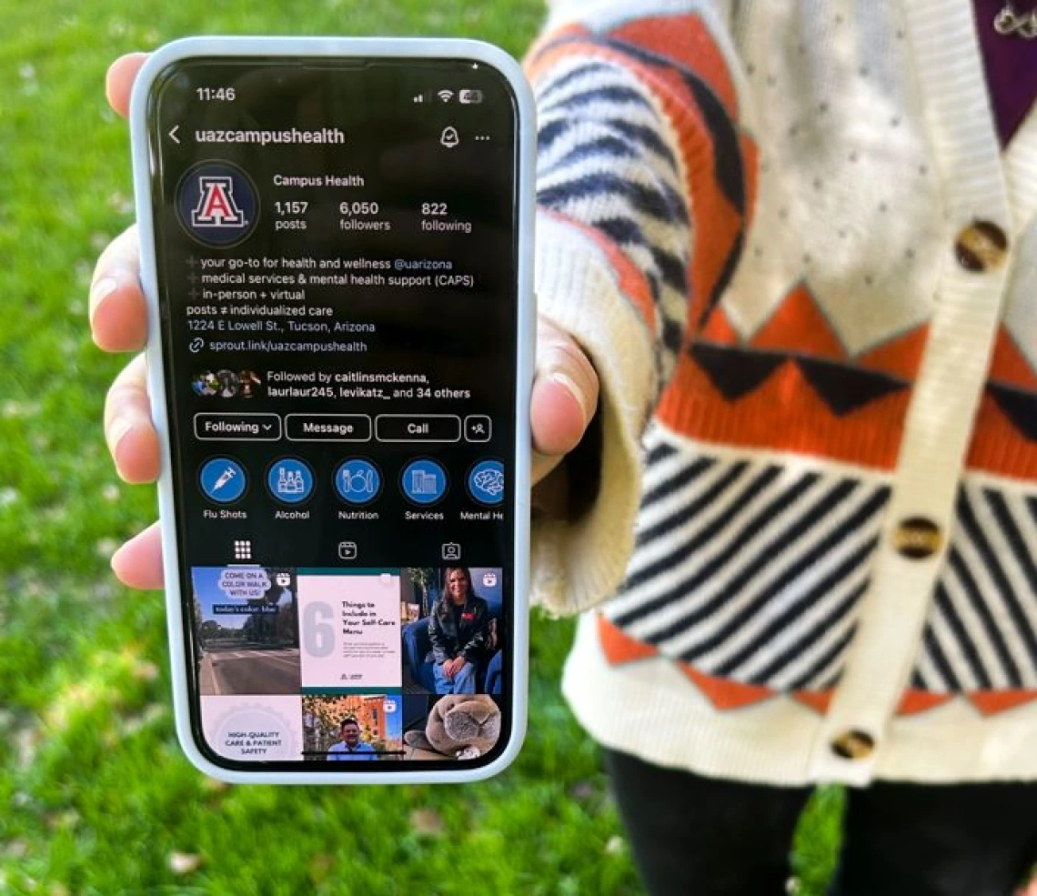 Person holding phone with @UAZCampusHealth instagram profile