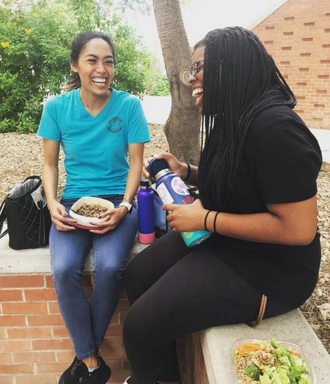 2 student sitting and laughing together