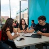 3 students sitting together at a table talking